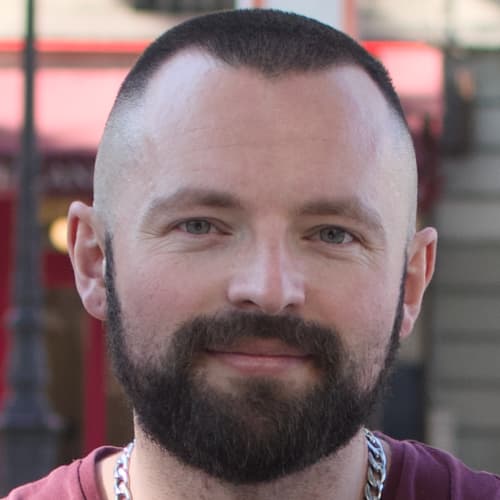 Dan Edwards headshot with beard and burgundy shirt