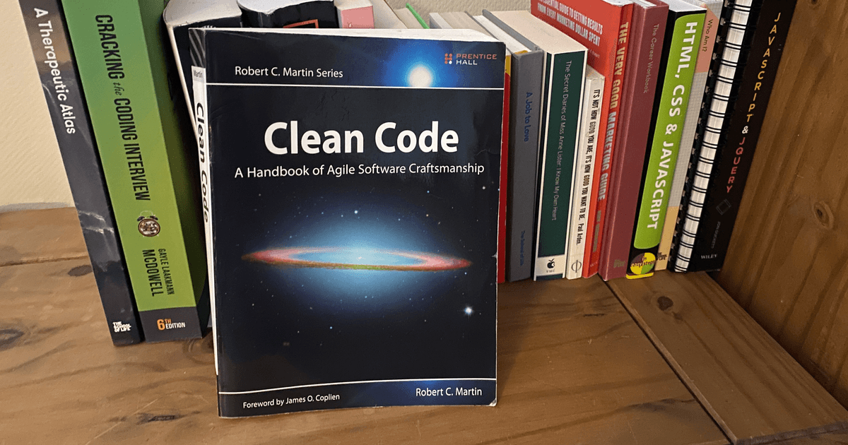 Clean Code book by Robert C. Martin on wooden bookshelf with other programming books